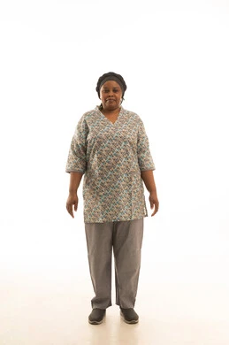 شغالة منزلية افريقية ملونة داكنة البشرة ترتدي يونيفورم رمادي اللون , بورتريه خلفية بيضاء الجسم بالطول الكامل ,نظرة امامية للكاميرا مع ايماءات سعادة