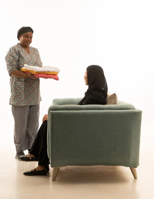 حسن المعاملة والحوار مع العمالة المنزلية ,امراة عربية خليجية سعودية محجبة ترتدي عباءة سوداء تجري حديث مع عاملة منزلية ملونة ذات بشرة سمراء ترتدي يونيفورم لون رمادي ,بورتريه خلفية بيضاء الجسم بالطول الكامل مع ايماءات السعادة