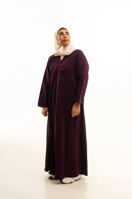 النظر الى شيء ما، مفهوم الانوثة والاناقة, الاهتمام بالمظهر الخارجي, بورترية لامرأة عربيه خليجية سعودية محجبة ترتدي العباءة تقف باستقامة و استعداد, صورة الجسم بالطول الكامل, خلفية بيضاء