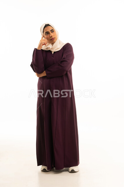 محاولة إيجاد حل لشيء ما, إيماءات الحيرة والقلق, التمعن والتركيز والتخطيط للمستقبل, بورتريه لإمرأة خليجية سعودية محجبة ترتدى العباءة تضع يدها على رأسها وتنظر بعيداً بتفكير وتأمل, محاولة إيجاد حل لشيء ما, الجسم بالطول الكامل, خلفية بيضاء