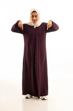 A portrait of a Saudi Arabian Gulf woman wearing a hijab and an abaya, pointing with her index finger downwards, looking at the camera with gestures of joy, confirming that something is happening at this moment, movements indicating this place (here), specifying a certain location, full-body shot, white background.