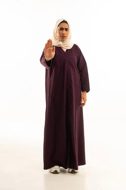 الشعور بالإنزعاج والغضب, الأمر بالتوقف عن فعل شيء ما, بورتريه لإمرأه عربيه خليجيه سعودية محجبه ترتدي العباءه ترفع يدها بإيماءات تدل على النهي, الجسم بالطول الكامل, خلفية بيضاء