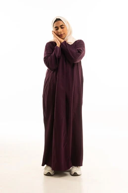 النعاس والتعب و الارهاق، السهر لوقت متأخر من الليل, بورتريه لإمرأه عربيه خليجيه سعودية محجبه ترتدي العباءه  تضع يديها تحت رأسها بإيماءات الخمول والكسل, الجسم بالطول الكامل, خلفية بيضاء