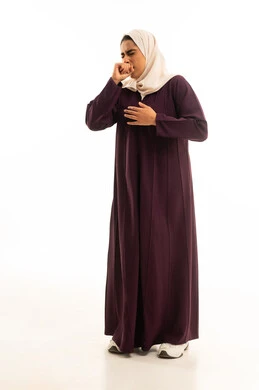 The concept of influenza infection, expressions of choking and shortness of breath, a portrait of a smiling Saudi Arabian Gulf woman wearing a hijab and an abaya, placing her hand over her mouth in coughing gestures, severe pain and illness, full-body, white background.