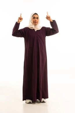 Looking up with gestures of joy, signals and hand movements indicating this place (here), pinpointing a specific location with gestures of cheerfulness, a portrait of a smiling, veiled Saudi Arabian Gulf woman wearing an abaya, raising her fingers and pointing to something, full-body, white background.