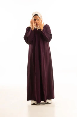 منع النظر لشيء ما, بورتريه لامرأة عربية خليجية سعودية محجبة ترتدي عباءة تقوم باخفاء وجهها بيديها, الجسم بالطول الكامل, خلفية بيضاء