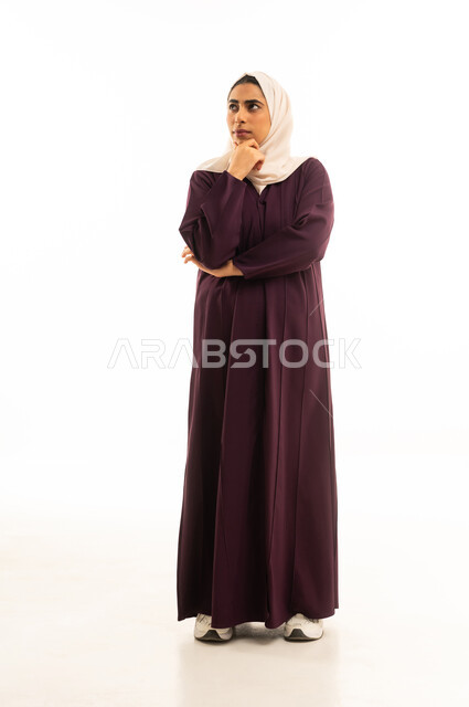 شرود الذهن والتأمل والتخطيط للمستقبل، التفكير لأيجاد حل مشكلة ما, بورتريه لامرأة عربية خليجية سعودية محجبة ترتدي عباءة تنظر الى الأعلى بإيماءات التمعن والتركيز، مواجهة المشكلات والتحديات في الحياة العملية, الجسم بالطول الكامل, خلفية بيضاء