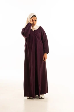 Love of research, exploration, and adventure, a portrait of a Gulf Arab Saudi woman wearing a hijab and an abaya, placing her hand over her eye in a lens-like gesture with facial expressions and hand movements indicating observation, the concept of future vision, full-body, white background.