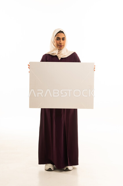 لوحة توضيحية ووسيلة تعليمية, بورتريه لإمرأة عربية خليجية سعودية محجبة ترتدي عباءة بنية تحمل بيدها موك اب مستطيل أبيض, الجسم بالطول الكامل, خلفية بيضاء