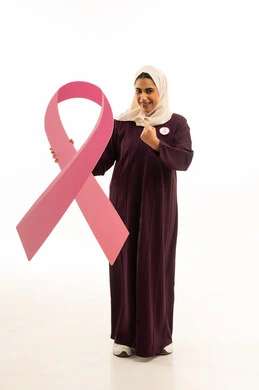 Encouragement, victory, and achieving the goal, a portrait of a Saudi Arabian Gulf woman wearing a hijab and an abaya holding a slogan for awareness of early detection of breast cancer, full-body, white background.