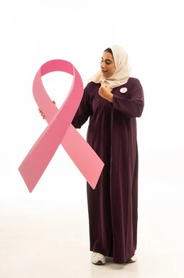 القوة والانتصار والتشجيع, بورتريه لإمرأة عربية خليجية سعودية محجبة ترتدي العباءة تمسك شعار التوعيه بالكشف المبكر لسرطان الثدي, الجسم بالطول الكامل, خلفية بيضاء