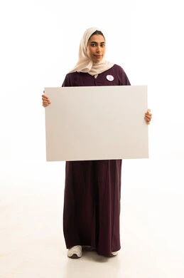 لوحة توعوية مستطيلة فارغة, بورتريه لإمرأة عربية خليجية سعودية محجبة ترتدي عباءة بنية تحمل بيدها موك اب مستطيل أبيض, , الجسم بالطول الكامل, خلفية بيضاء