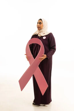 التأمل والنظر للاعلى, بورتريه لامرأة عربية خليجية سعودية مبتسمة محجبة ترتدي العباءة البنية  و شعار التوعيه بالكشف المبكر تنظر الى شىء ما، الحملة التوعويه بالمرض الخبيث، الجسم بالطول الكامل, خلفية بيضاء
