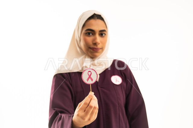 الاناقة والاهتمام بالظهر الخارجي, بورتريه مقرب لامرأة عربية خليجية سعودية مبتسمة محجبة ترتدي العباءة البنية  و شعار التوعيه بالكشف المبكر لسرطان الثدي، الحملة التوعويه بالمرض الخبيث، الجسم بالطول الكامل, خلفية بيضاء