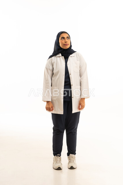 بورتريه لامرأة عربية خليجية سعودية محجبة ترتدي الزى الكاجوال تنظر الى شىء ما, التأمل والنظر للاعلى، الاناقة والاهتمام بالظهر الخارجي، الجسم بالطول الكامل, خلفية بيضاء