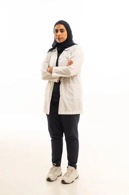 Standing with crossed arms, elegance and attention to external appearance, a portrait of a Saudi Arabian Gulf woman wearing a hijab in casual attire looking at the camera, full body, white background.