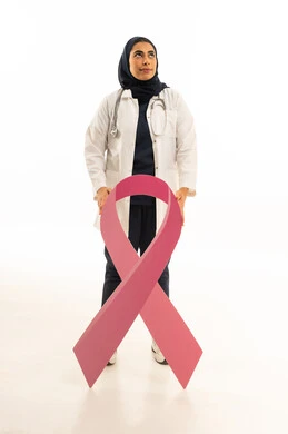 Looking at something above, a portrait of a Saudi Arabian Gulf female doctor wearing a white coat and a stethoscope, holding the pink awareness logo for early breast cancer detection, full body, white background.
