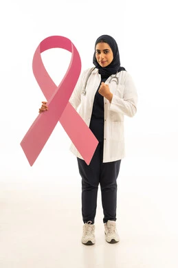 رفع قبضة اليد بتعابير السعادة والنصر, بوتريه لامرأة عربية خليجية سعودية محجبة ترتدي الزى الكاجوال و السماعة الطبية تمسك بيديها شعار الحملة العالمية الوردى لمكافحة سرطان الثدى, النظر إلى الكاميرا بايماءات الثقة بالنفس, خلفية بيضاء