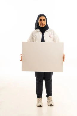 لوحة توعوية مستطيلة فارغة, بوتريه لامرأة عربية خليجية سعودية محجبة ترتدي الزى الكاجوال و شعار الحملة العالمية لسرطان الثدى تحمل بيدها موك اب مستطيل أبيض, خلفية بيضاء