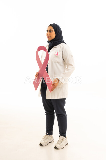 تقديم المساعدة والدعم من خلال الكشف المبكر عن سرطان الثدي، بوتريه من الجانب لامرأة عربية خليجية سعودية محجبة ترتدي الزى الكاجوال تمسك بيديها شعار الحملة العالمية, خلفية بيضاء