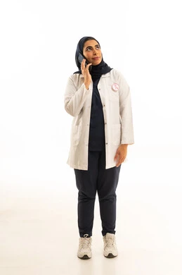 The slogan for the World Awareness Day for Early Detection of Breast Cancer, the awareness campaign for malignant diseases, looking towards the distant horizon with future perspectives, a portrait of a Saudi Gulf Arab woman in a hijab wearing casual attire talking on a mobile phone, white background.