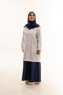 طبيبة عربية خليجية سعودية محجبة ترتدي عباءة زرقاء ومعطف طبي ابيض , الوقوف بشموخ و اعتزاز , النظر الى شئ ما , خلفية بيضاء , الجسم بالطول الكامل