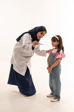 A Saudi Arabian Gulf Arab female doctor in a hijab wearing a white medical coat is showing a girl her temperature, a Saudi Arabian Gulf Arab girl in casual attire is monitoring the thermometer, portrait with a white background, full body.