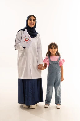 طبيبة عربية خليجية سعودية محجبة ترتدي المعطف الطبي الابيض تحمل راية الهلال الاحمر السعودي , طفلة عربية خليجية سعودية ترتدي الزي الكاجوال تقف بجانب الطبيبة , ايماءات السعادة , بورتريه خلفية بيضاء , الجسم بالطول الكامل , النظر للكاميرا