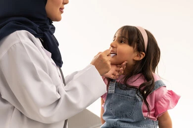 تقديم التطعميات المجانية للاطفال الصغار في هيئة الهلال الاحمر السعودي , طبيبة عربية خليجية سعودية محجبة تقوم باعطاء الجرعة المحددة و المناسبة للفتاة الصغيرة , طفلة عربية خليجية سعودية ترتدي الزي الكاجوال تتلقى التطعيمات اللازمة للوقاية من الامراض , بورتريه مقرب , خلفية بيضاء