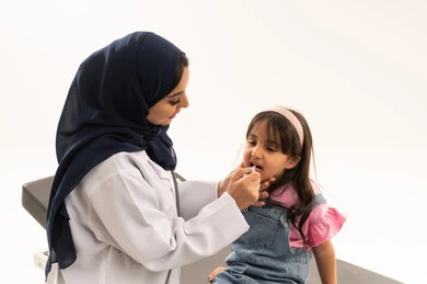 التطعيمات الرئيسية الضرورية للاطفال متاحة مجاناً في هيئة الهلال الاحمر السعودي , طبيبة عربية خليجية سعودية تقوم بتطعيم طفلة صغيرة من الامراض المعدية  , طفلة عربية خليجية سعودية ترتدي الزي الكاجوال تتلقى جرعة التطعيم المحددة و المناسبة لها , بورتريه مقرب , خلفية بيضاء