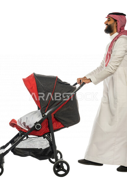 بورتريه من الجانب لرجل عربي خليجي سعودي يجرعربة الأطفال ، رابطة الأبوة ، ترابط عاطفي ، مفهوم الأسرة السعيدة ، نزهة و جولة عائلية ، قضاء أوقات عائلية ممتعة