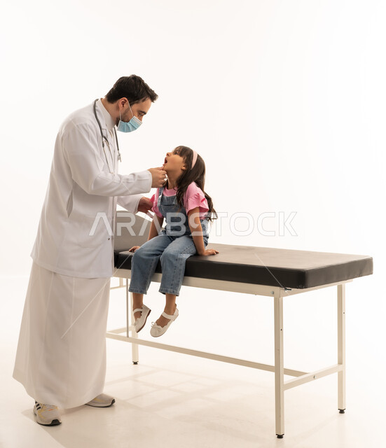 The use of a medical mask to limit infection during a medical examination, a Gulf Arab Saudi doctor wearing a mask while examining the teeth of a little girl, a small Gulf Arab Saudi girl wearing casual attire sitting quietly during a routine dental check-up, portrait with a white background, full body.