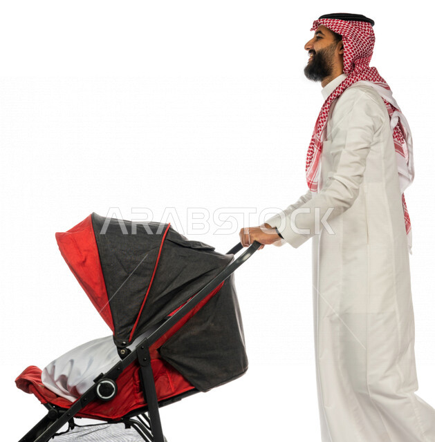 بورتريه من الجانب لرجل عربي خليجي سعودي يجرعربة الأطفال ، رابطة الأبوة ، ترابط عاطفي ، مفهوم الأسرة السعيدة ، نزهة و جولة عائلية ، قضاء أوقات عائلية ممتعة