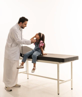 قياس درجة النظر و العناية بالعيون منذ الصغر في هيئة الهلال الاحمر السعودي , طبيب عيون عربي خليجي سعودي يرتدي المعطف الابيض الطبي يقوم بفحص عيون الصغيرة  , طفلة عربية خليجية سعودية ترتدي الزي الكاجوال تستعد لقياس قوة النظر , بورتريه خلفية بيضاء, الجسم بالطول الكامل