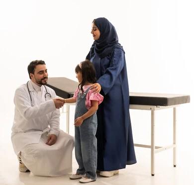 طبيبة عربية خليجية سعودية محجبة ترتدي عباءة زرقاء تقف بجوار الطفلة لمساعدتها ,طبيب عربي خليجي سعودي يرتدي المعطف الطبي الابيض يجلس القرفصاء امام طفلة صغيرة بابتسامة بعد استقرار الحالة و الاطمئنان على الصحة , بورتريه خلفية بيضاء , الجسم بالطول الكامل