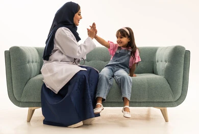 The relationship of love and affection between doctors and patients, an Arab Gulf Saudi female doctor wearing a blue abaya and a white medical coat sitting on the sofa next to a girl, an Arab Gulf Saudi girl wearing casual attire shaking hands with the doctor cheerfully and happily, portrait with a white background, full body. The relationship of love and affection between doctors and patients, an Arab Gulf Saudi female doctor wearing a blue abaya and a white medical coat sitting on the sofa next to a girl, an Arab Gulf Saudi girl wearing casual attire shaking hands with the doctor cheerfully and happily, portrait with a white background, full body.