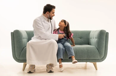 Ensuring the heart's safety and health, an Arab Gulf Saudi girl wearing casual attire looks at the doctor during routine check-ups, an Arab Saudi Gulf doctor listens to the little girl's heartbeat to reassure her health, portrait with a white background, full-body.