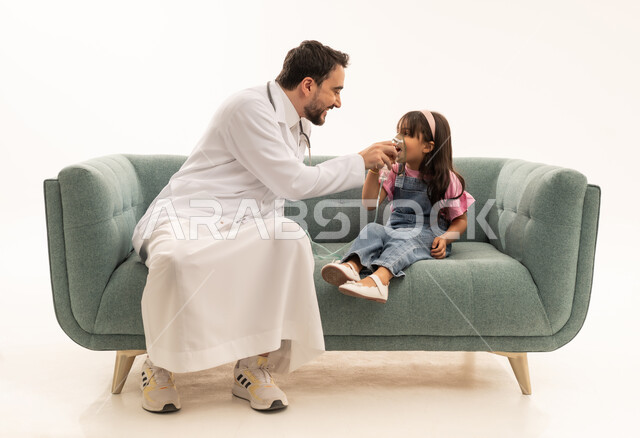 بورتريه خلفية بيضاء الجسم بالطول الكامل , طبيب عربي خليجي سعودي يرتدي المعطف الطبي الابيض يقوم بوضع قناع التنفس للمريضة , طفلة عربية خليجية سعودية ترتدي الزي الكاجوال تجلس على الاريكة , تقديم المساعدة اللازمة بسرعة ,