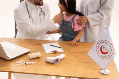 A close-up portrait of a girl sitting calmly and confidently on a medical examination chair, an Arab Saudi Gulf female doctor in a hijab assisting the girl during the examination, and an Arab Gulf Saudi male doctor wearing a white coat examining the teeth to ensure their health.