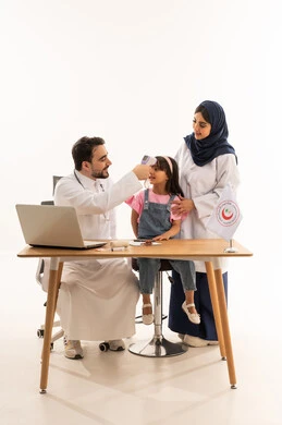 An Arab Gulf Saudi female doctor wearing a white medical coat holds the child's hand while measuring her temperature. An Arab Gulf Saudi male doctor in a medical coat is checking the child's temperature to ensure her safety. Full-body portrait with a white background.