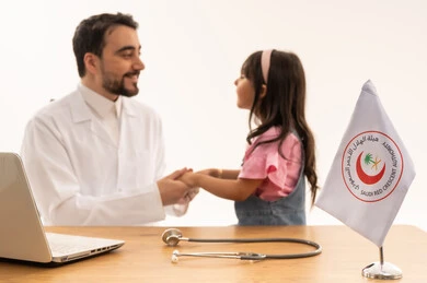 حديث لطيف من الطفلة الصغيرة مع الطبيب ,طفلة عربية خليجية سعودية صغيرة ترتدي الزي الكاجوال تشعر بالامان و السعادة بعد الاطمئنان على صحتها ,طبيب عربي خليجي سعودي يرتدي المعطف الطبي الابيض فوق الثوب السعودي يستمع بانصات الى المريضة الصغيرة ,بورتريه مقرب ,خلفية بيضاء