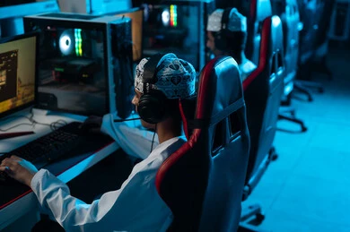 لعب الالعاب الالكترونية الجماعية عن بعد باستخدام خدمات الانترنت , شابان عربيان خليجيان عمانيان يرتديان دشداشة بيضاء و كمة مطرزة يجلسان امام شاشة الحاسب المكتبي , التواصل مع اللاعبيين المشاركين في اللعبة بسهولة