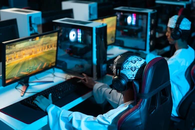 الجلوس امام جهاز الحاسب المكتبي , شابان عربيان خليجيان عمانيان يرتديان الدشداشة البيضاء و الكمة المطرزة , الالعاب الالكترونية المثيرة بين الاصدقاء , النظر الى الشاشة