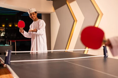 حمل الكرة الصغيرة البيضاء داخل كف اليد , شاب عربي خليجي عماني يرتدي الدشداشة البيضاء و الكمة المطرزة , الاستعداد لبدء اللعبة الحماسية , ايماءات السعادة , صورة مقربة