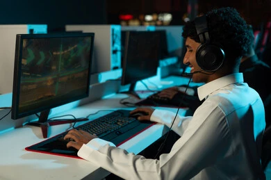 النظر الي شاشة الحاسب بابتسامة و سعادة , رجل عربي خليجي سعودي يرتدي الثوب الابيض ينقر على لوحة المفاتيح , اللعب بشغف و حماس , ايماءات السعادة و البهجة