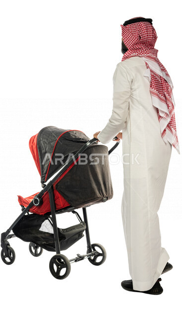 بورتريه من الخلف لرجل عربي خليجي سعودي يجرعربة الأطفال ، رابطة الأبوة ، ترابط عاطفي ، مفهوم الأسرة السعيدة ، نزهة و جولة عائلية ، قضاء أوقات عائلية ممتعة