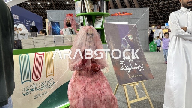 مركز الأدب العربي، تصوير لمجسم يرتدي فستان زفاف وردي اللون، أداة ترويجية لرواية بعنوان "عروس برشلونة"، معرض الكتاب الدولي في جدة 16 من ديسمبر 2025 ، المعالم والأماكن السياحية الثقافية المشهورة فى المملكة العربية السعودية، استقطاب وجذب السياح من أنحاء العالم ، فعاليات موسم الرياض