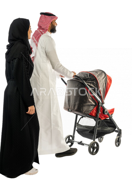 بورتريه من الخلف لرجل عربي خليجي سعودي يجرعربة الأطفال برفقة زوجته ، ترابط عاطفي ، مفهوم الأسرة السعيدة ، نزهة و جولة عائلية ، قضاء أوقات عائلية ممتعة