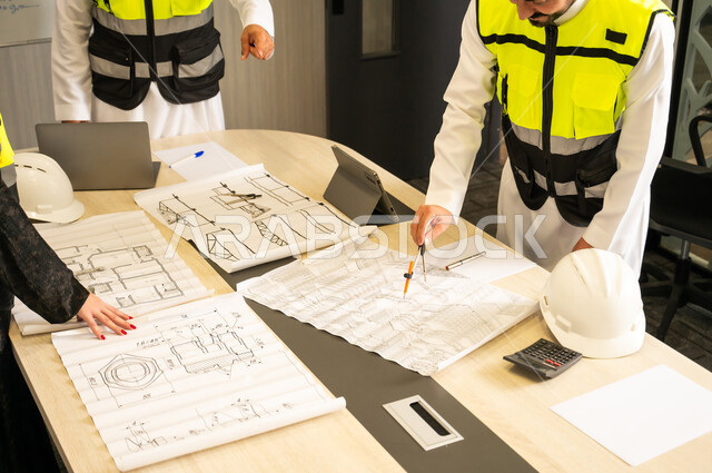 Planning and preparing architectural drawings, technical supervision of the implementation of engineering plans, companies specialized in construction workshops and contracting, a group of Arab Gulf Saudi engineers working on discussing the construction plan and accurately adjusting measurements within the company's headquarters.