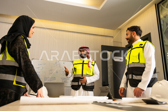 Technical supervision of the implementation of engineering plans, specialized companies in construction workshops and contracting, planning and preparing architectural drawings, a group of Arab Gulf Saudi engineers working on discussing the construction plan and accurately adjusting measurements within the company's headquarters.
